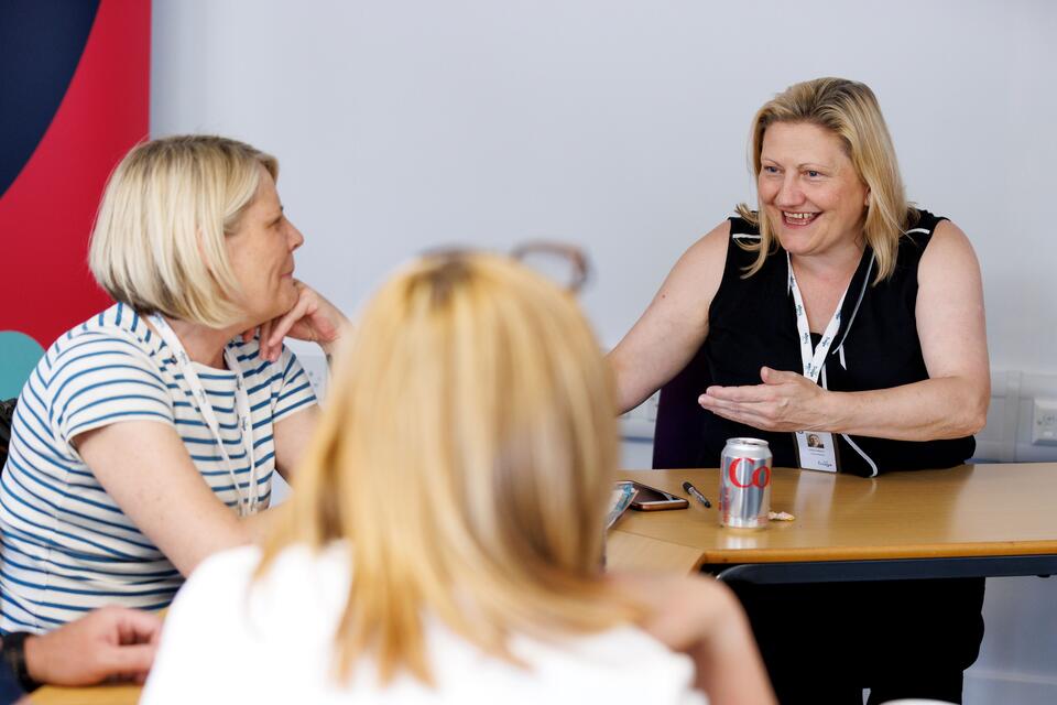 Two women talking and smiling.