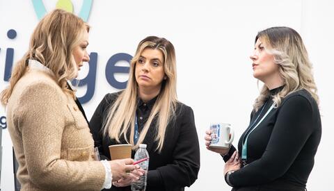 Women talking at a work event.