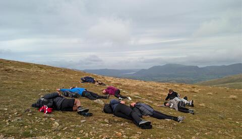 Group laying down having climbed the mountain.
