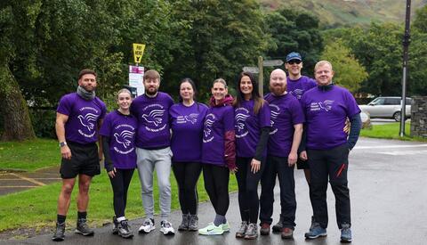 Male and females posing for camera wearing purple t-shirts with the branding, Alice House Hospice