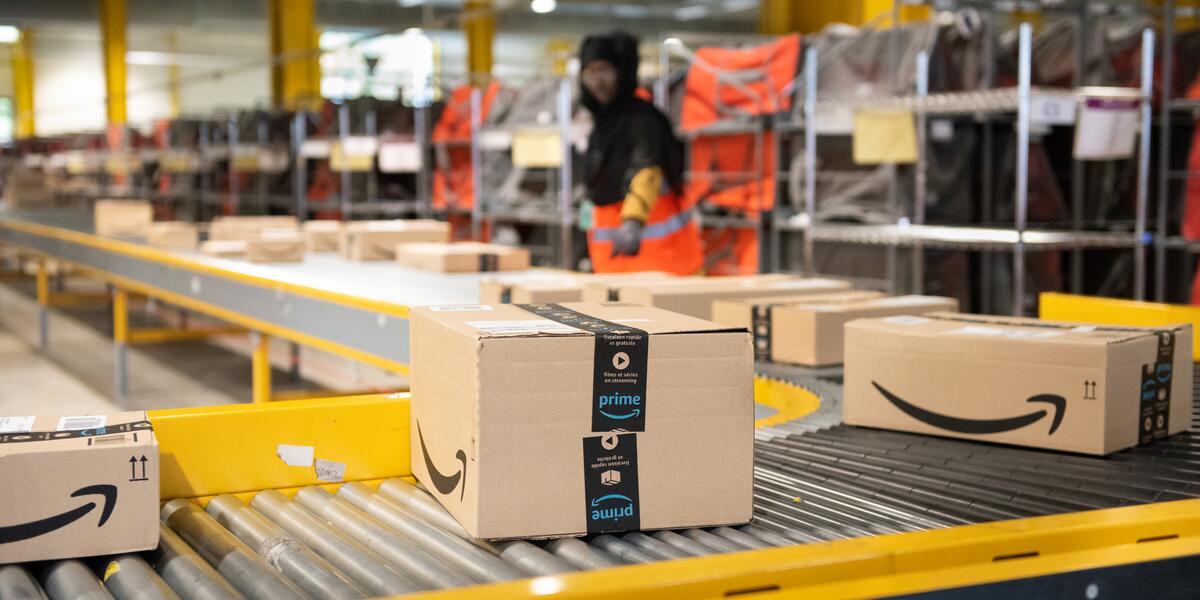  Logistics activity on the Amazon site. Packages are sorted by workers on conveyors.