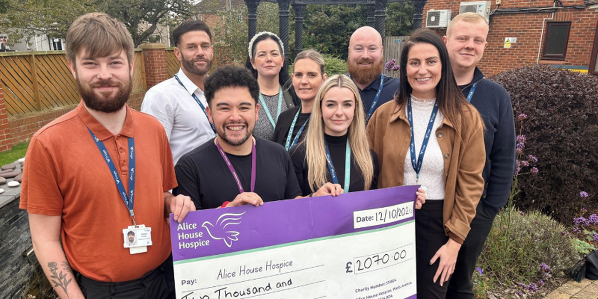 Group of men and woman holding a cheque for £2070 for Alice House Hospice