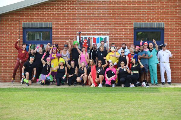 Group of people in fancy dress smiling and cheering.